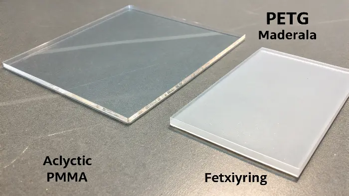 A flexible PETG bottle next to a rigid, clear acrylic sign